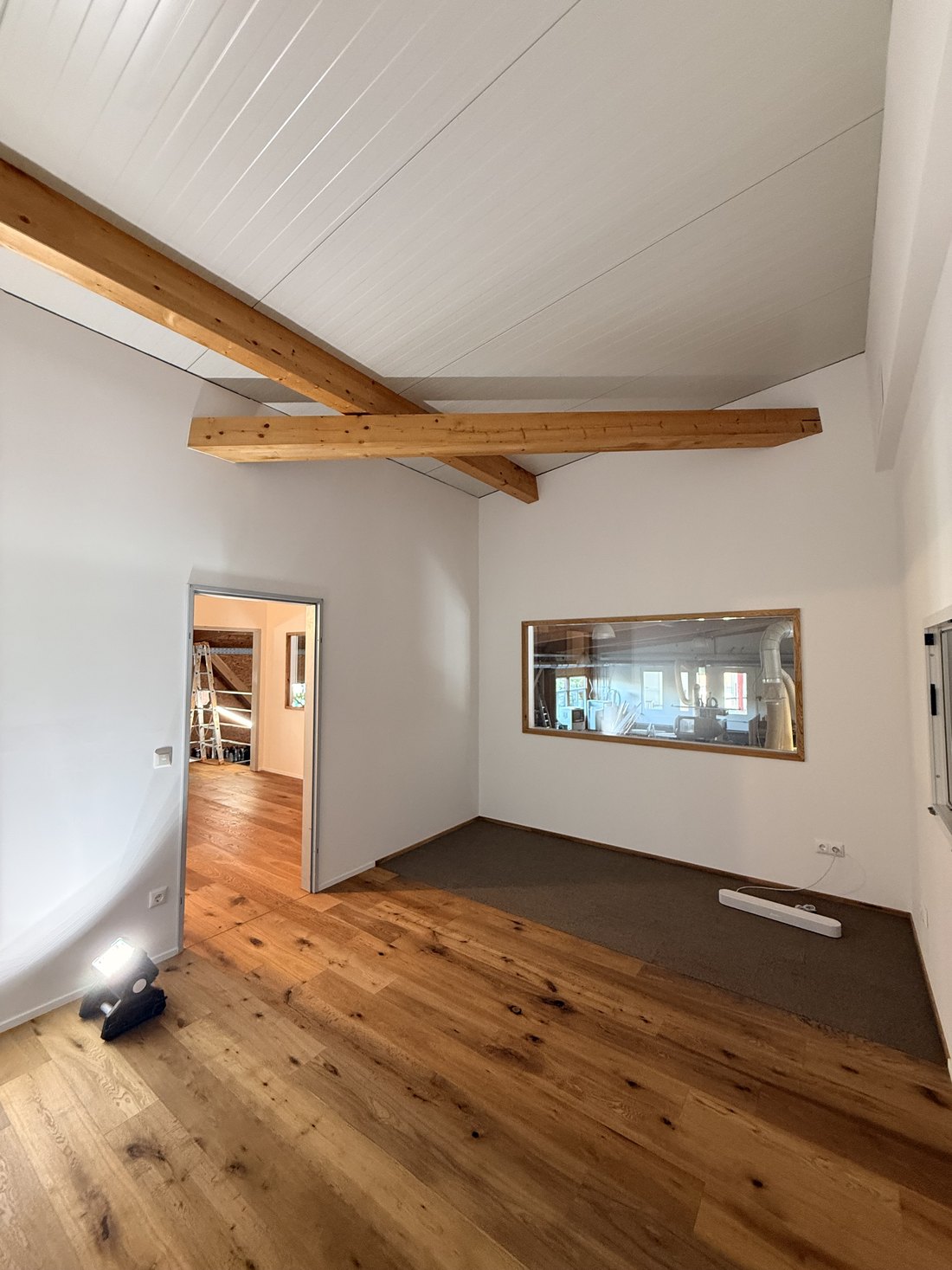 Ausgebauter Dachraum mit weißer Deckenverkleidung und sichtbaren Balken